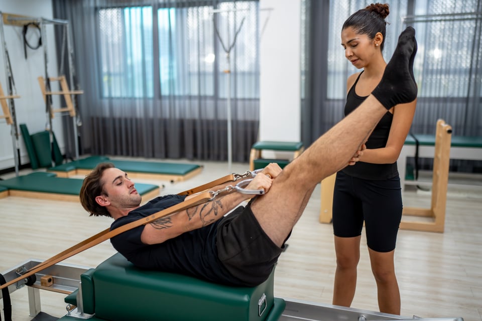 man-exercising-on-pilates-reformer-bed-2025-01-31-05-19-15-utc